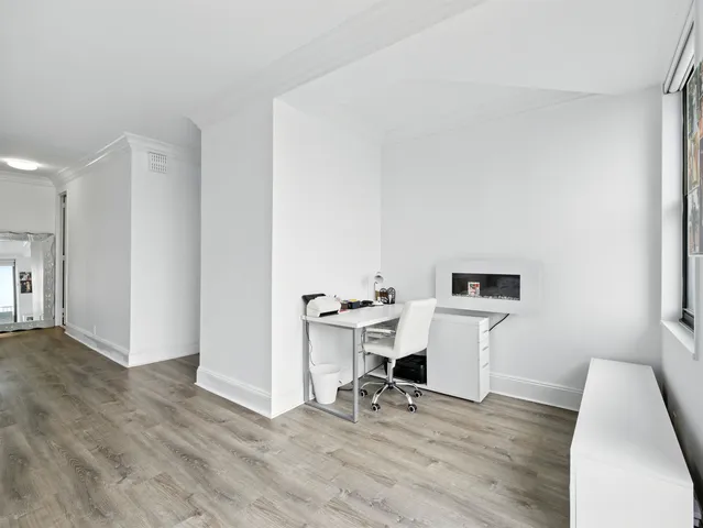 a view of a workspace with furniture and wooden floor
