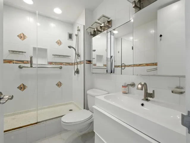 a bathroom with a sink a toilet and shower