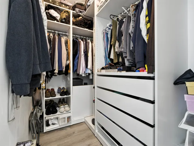 a view of walk in closet with clothes and shoes