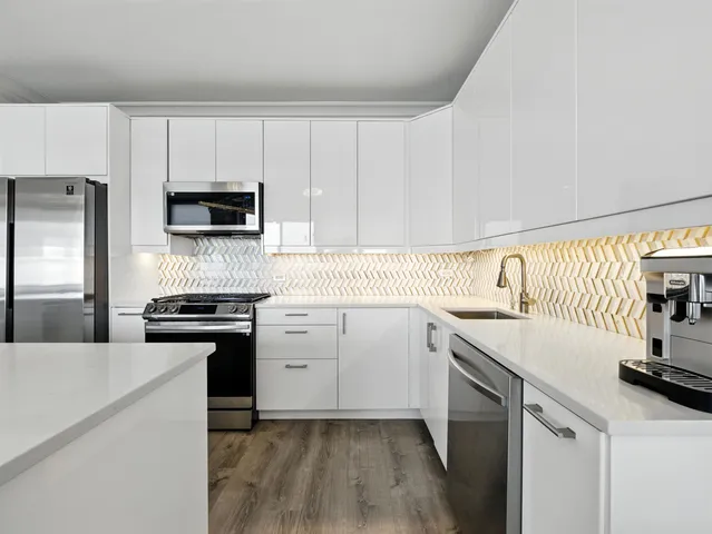 a kitchen with a sink a stove and cabinets