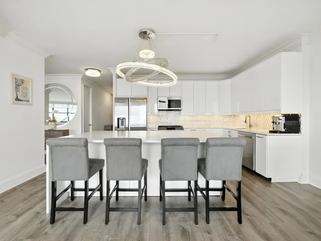 a kitchen with a dining table chairs and white cabinets