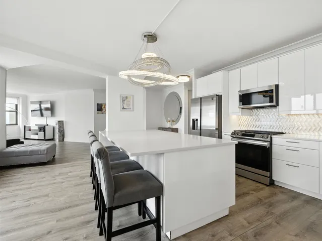 a kitchen with microwave a stove and chairs