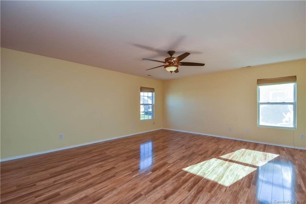 8716 Chalkstone Road Charlotte, NC 28216 - Photo 14 of 31 a view of empty room with wooden floor and fan