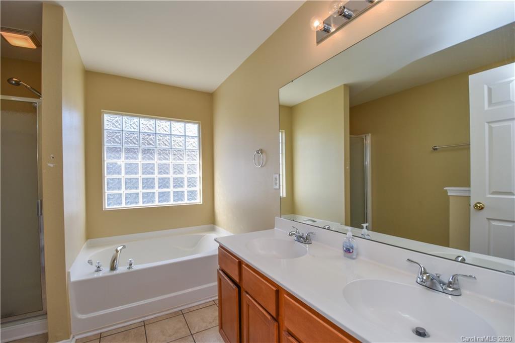 8716 Chalkstone Road Charlotte, NC 28216 - Photo 17 of 31 a bathroom with a tub sink and mirror