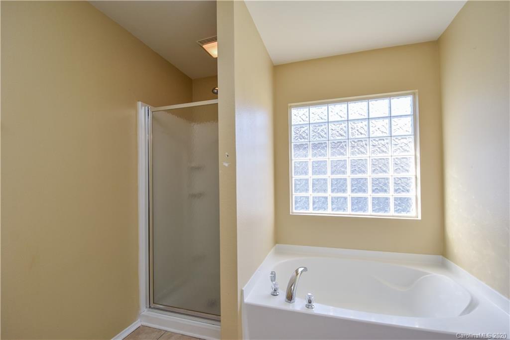 8716 Chalkstone Road Charlotte, NC 28216 - Photo 18 of 31 a white bath tub sitting next to a window