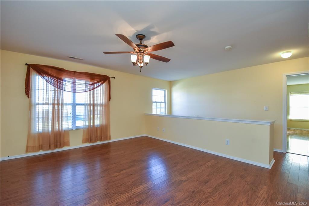 8716 Chalkstone Road Charlotte, NC 28216 - Photo 19 of 31 a view of an empty room with window and wooden floor