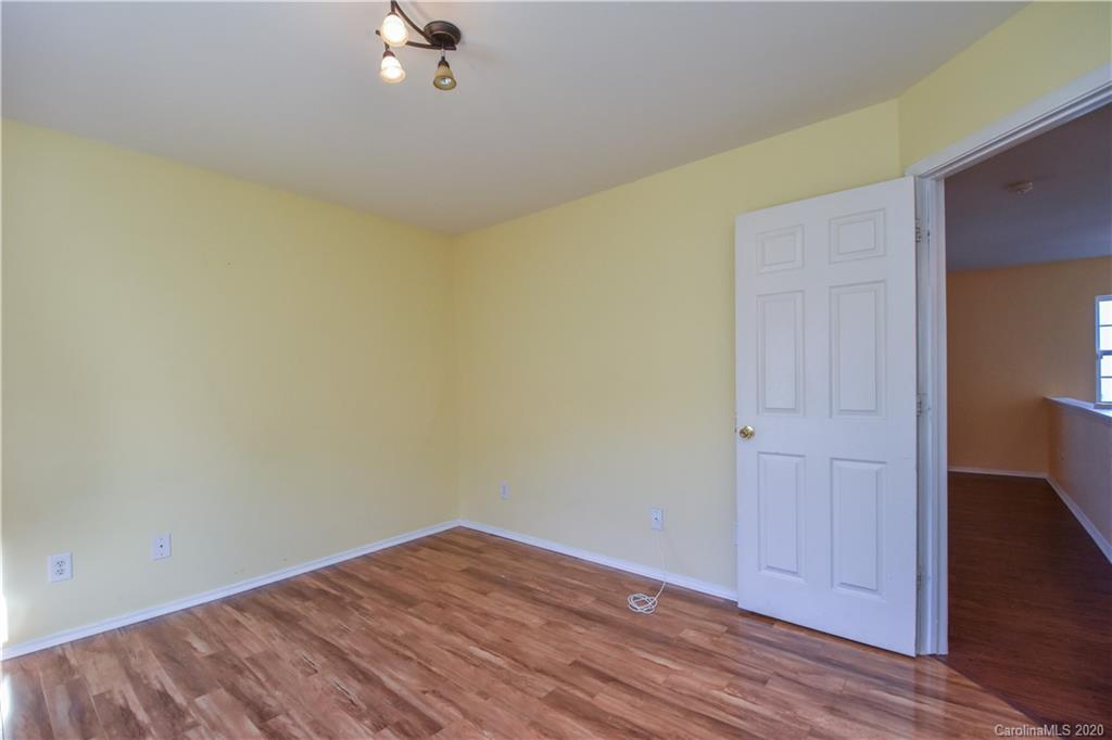 8716 Chalkstone Road Charlotte, NC 28216 - Photo 22 of 31 a view of a room with wooden floor and a ceiling fan