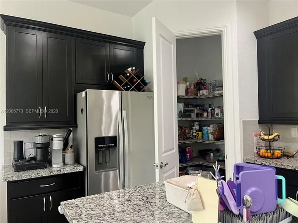 a kitchen with a refrigerator and a stove top oven