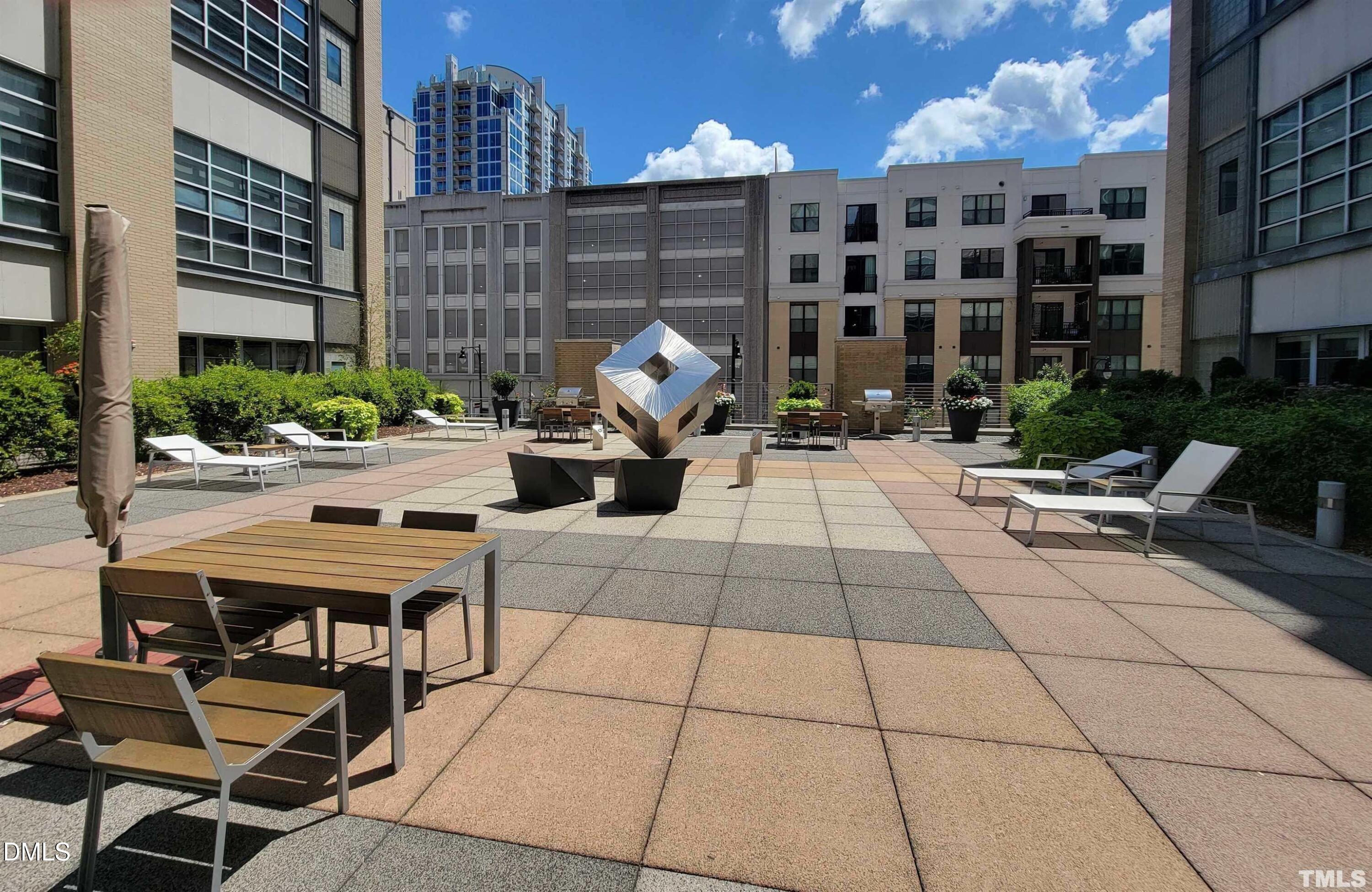 319 Fayetteville Street, Unit 410 Raleigh, NC 27601 - Photo 26 of 28 a view of a patio with dining table and chairs with a potted plants