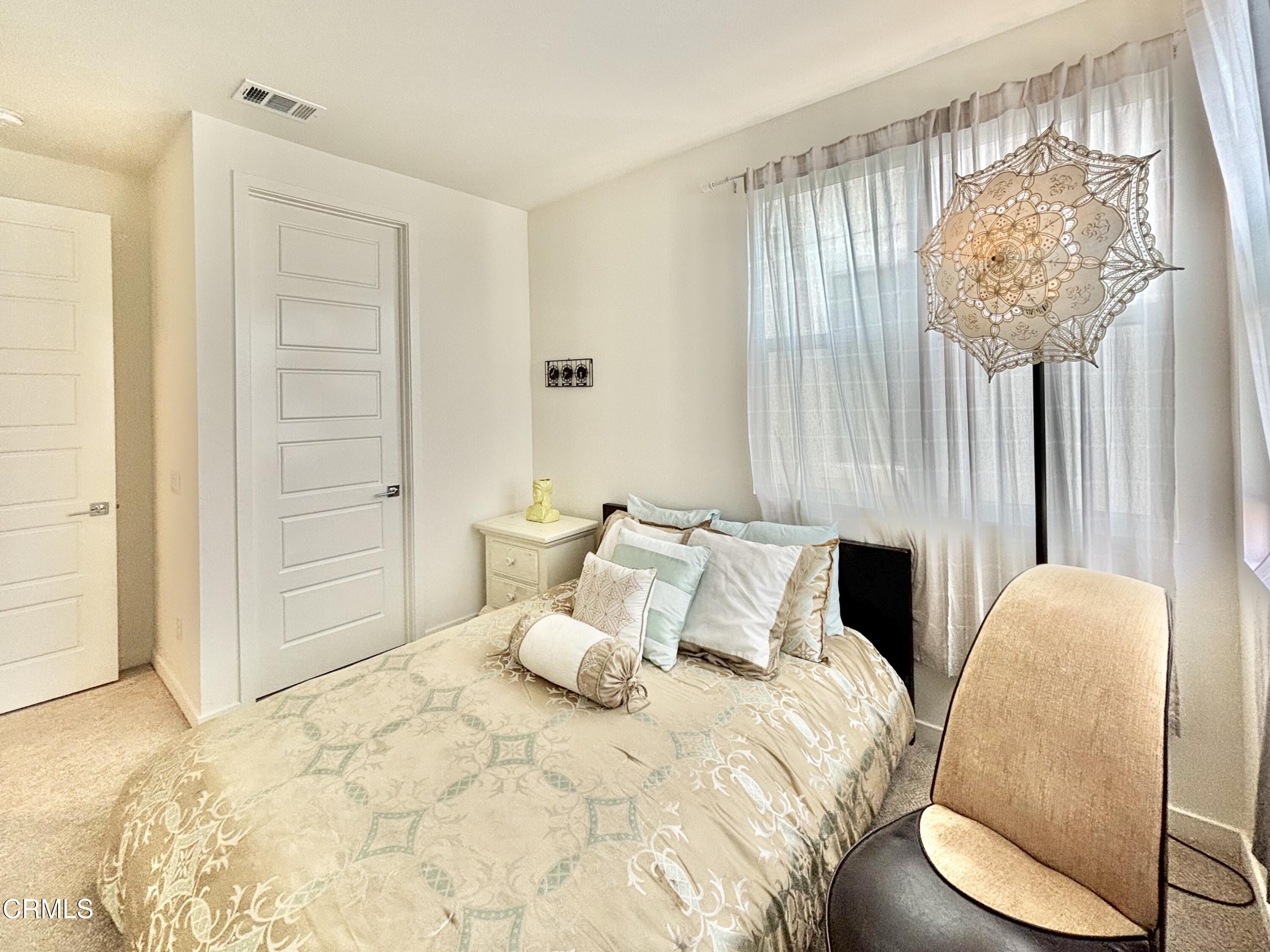 1105 Canal Street Oxnard, CA 93035 - Photo 12 of 14 a bedroom with a bed and a chandelier