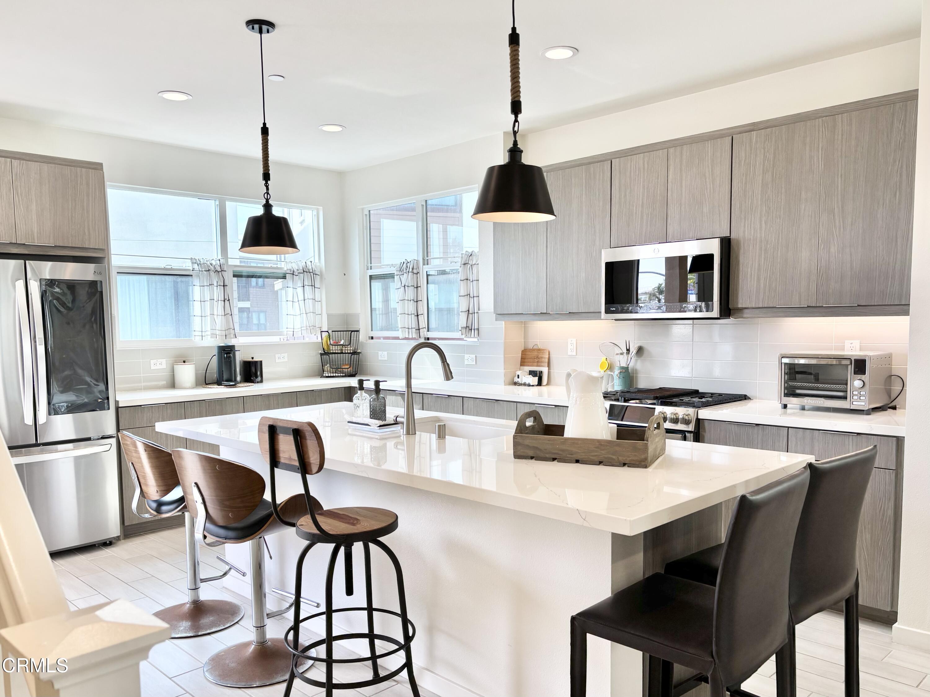 1105 Canal Street Oxnard, CA 93035 - Photo 2 of 14 a kitchen with stainless steel appliances a stove a sink a microwave a center island and a cabinets