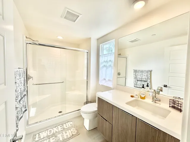 a bathroom with a sink toilet double vanity and shower