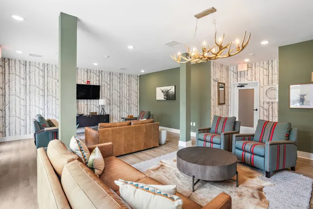 a living room with furniture a fireplace and a chandelier