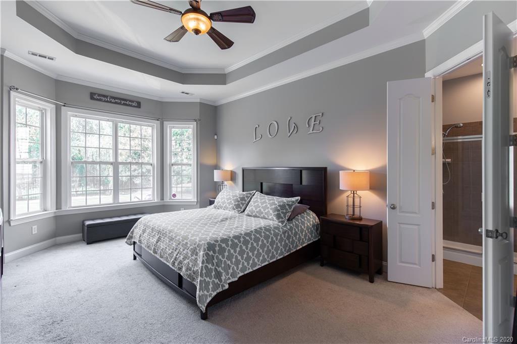 313 Miners Cove Way Fort Mill, SC 29708 - Photo 15 of 38 a spacious bedroom with a large bed and a chandelier