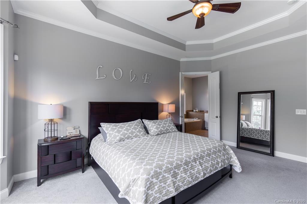 313 Miners Cove Way Fort Mill, SC 29708 - Photo 16 of 38 a bedroom with a large bed and a chandelier