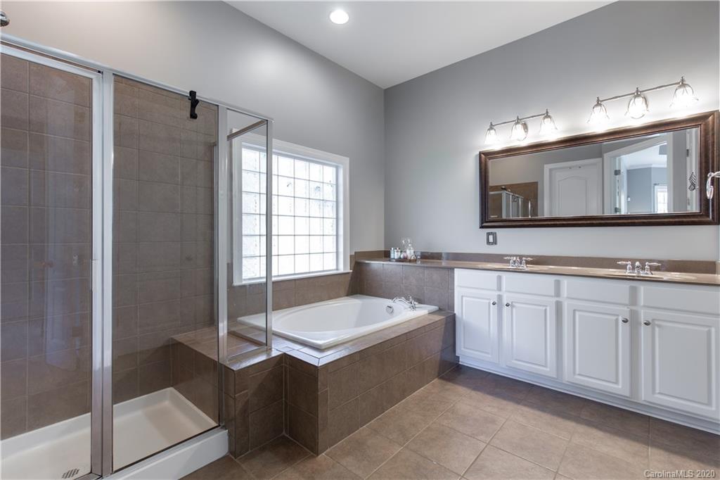 313 Miners Cove Way Fort Mill, SC 29708 - Photo 17 of 38 a bathroom with a tub sink and mirror