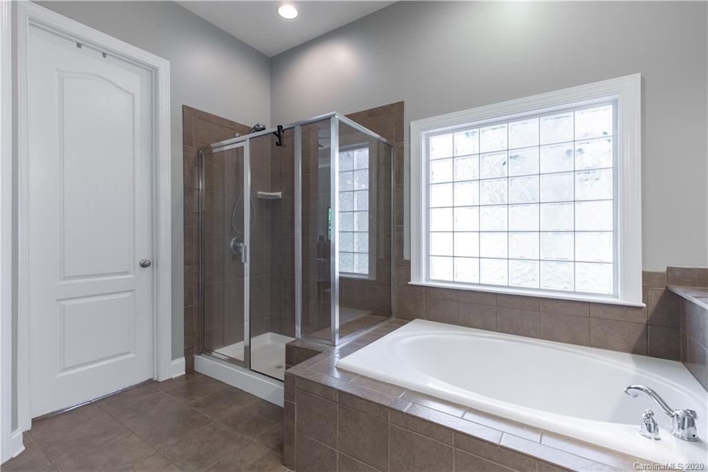 313 Miners Cove Way Fort Mill, SC 29708 - Photo 18 of 38 a bathroom with a bathtub and a shower