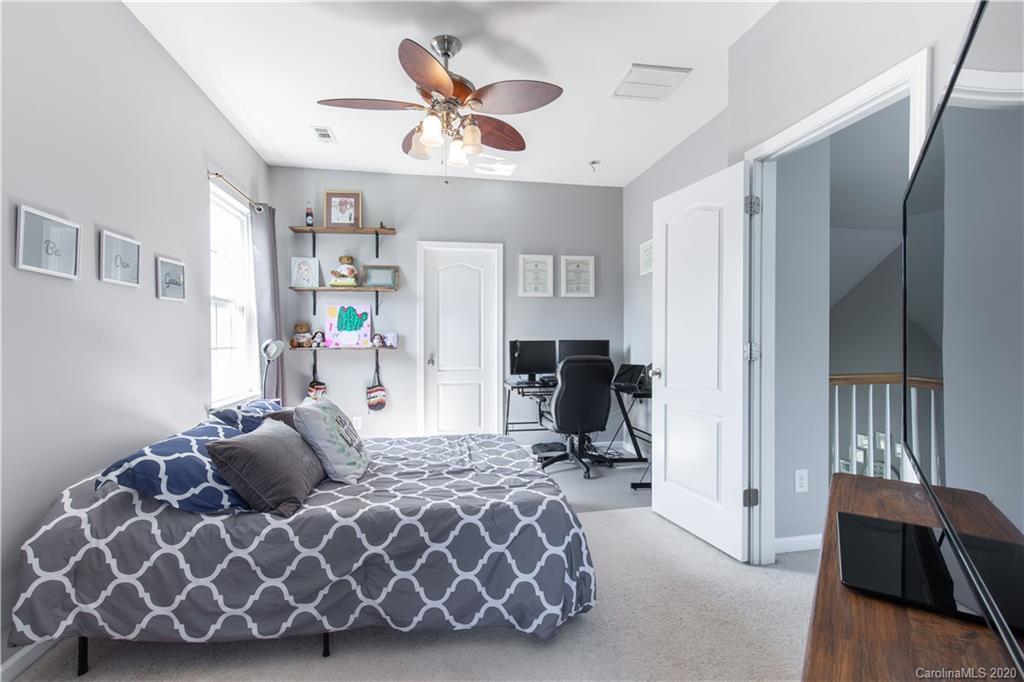 313 Miners Cove Way Fort Mill, SC 29708 - Photo 28 of 38 a spacious bedroom with a bed and a chandelier
