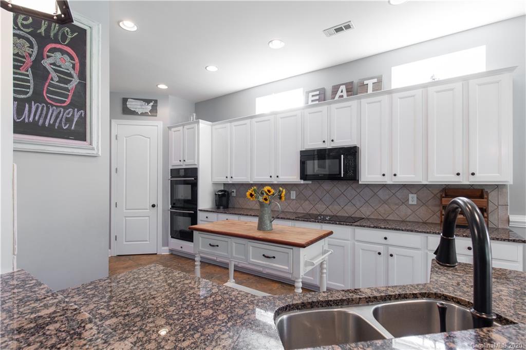 313 Miners Cove Way Fort Mill, SC 29708 - Photo 10 of 38 a kitchen that has a sink and a stove in it