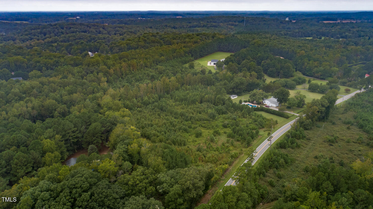 9841 Quail Roost Road Bahama, NC 27503 - Photo 6 of 12 a view of a lush green forest with trees and some houses