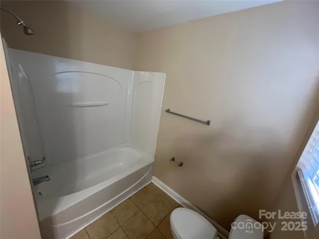a bathroom with a granite countertop toilet and a shower