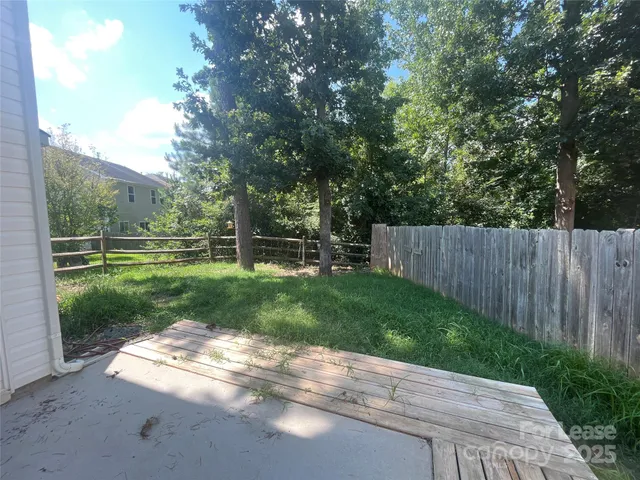 a view of a yard with wooden fence