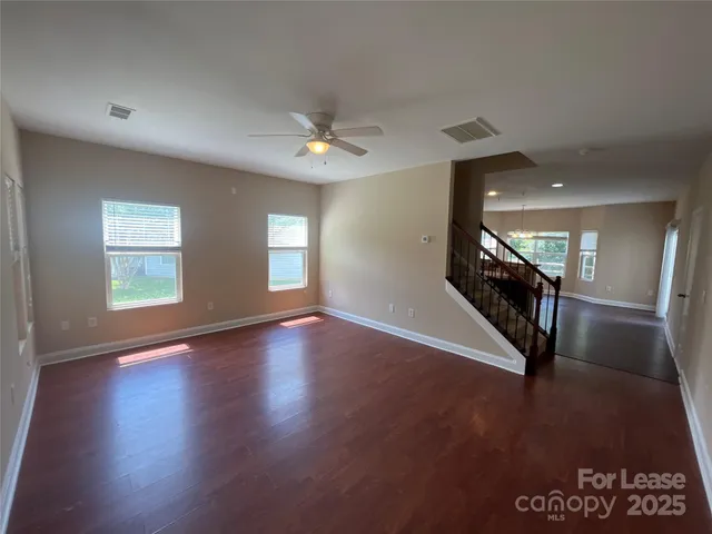 a view of a livingroom with wooden floor and stairs