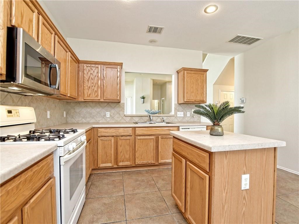 1117 Rawhide Trail Cedar Park, TX 78613 - Photo 13 of 36 a kitchen with stainless steel appliances granite countertop a sink stove and cabinets