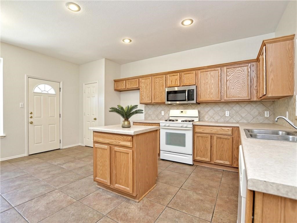 1117 Rawhide Trail Cedar Park, TX 78613 - Photo 14 of 36 a kitchen with a stove top oven sink and cabinets