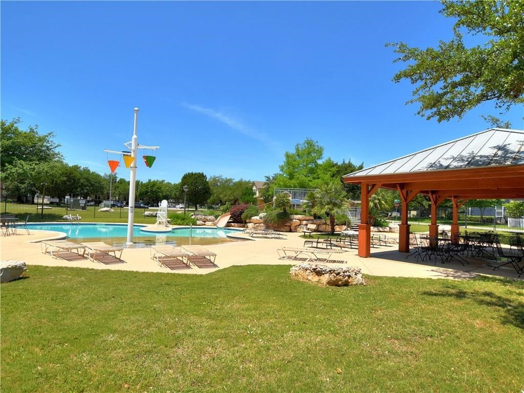 1117 Rawhide Trail Cedar Park, TX 78613 - Photo 32 of 36 a view of a swimming pool with a table and chairs under an umbrella