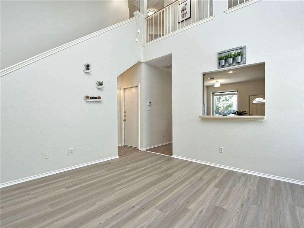 1117 Rawhide Trail Cedar Park, TX 78613 - Photo 9 of 36 a view of an empty room with wooden floor and a window