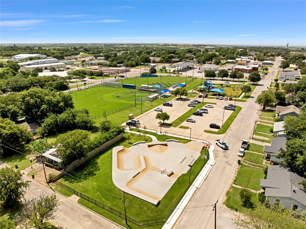 501 North Miller Street Decatur, TX 76234 - Photo 24 of 24 Open-air concrete skate park, adjacent green space, paved parking area, nearby baseball field, and recreational playground structures