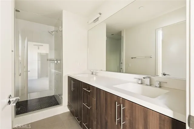 a bathroom with a double vanity sink mirror and shower