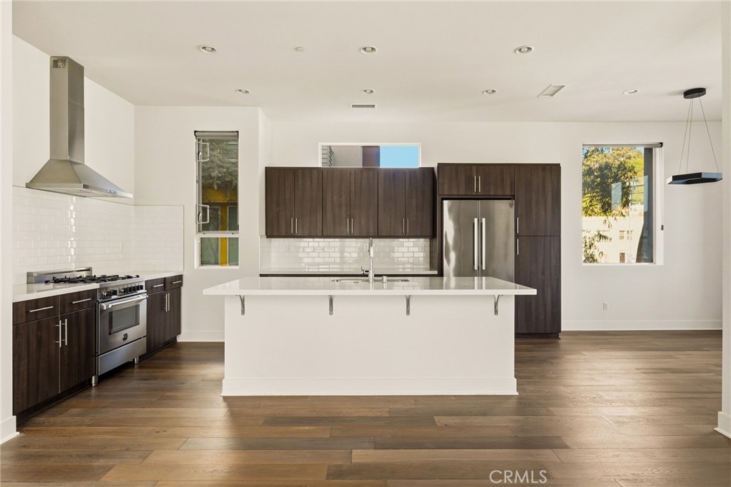 2201 Tom Mix Road Silver Lake, CA 90026 - Photo 5 of 25 a kitchen with stainless steel appliances wooden floors and wooden cabinets