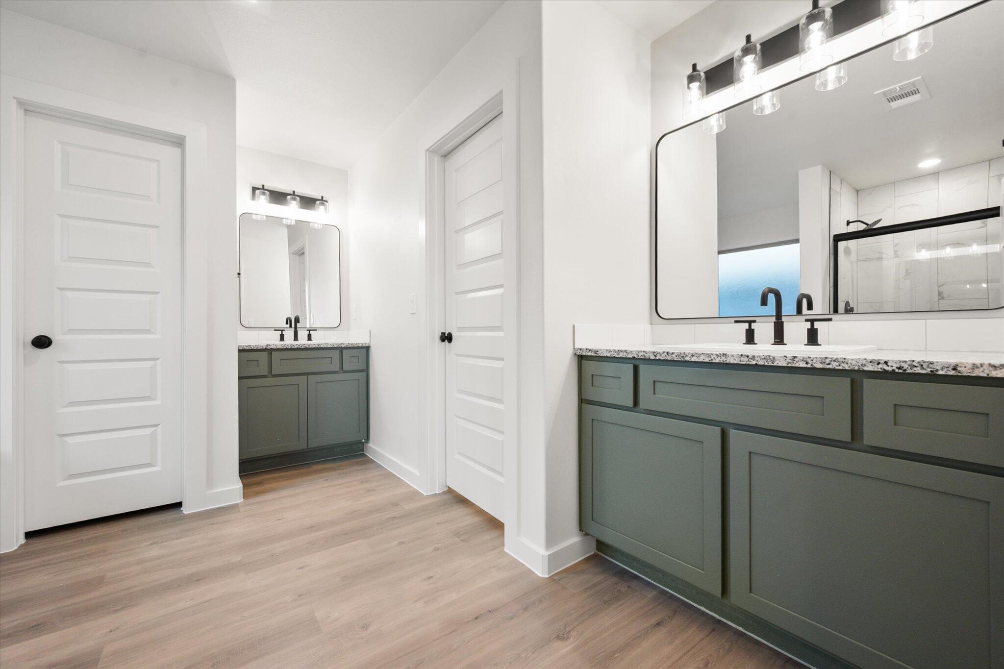 7006 56th Street Lubbock, TX 79407 - Photo 13 of 22 a bathroom with a double vanity sink a mirror and a bathtub