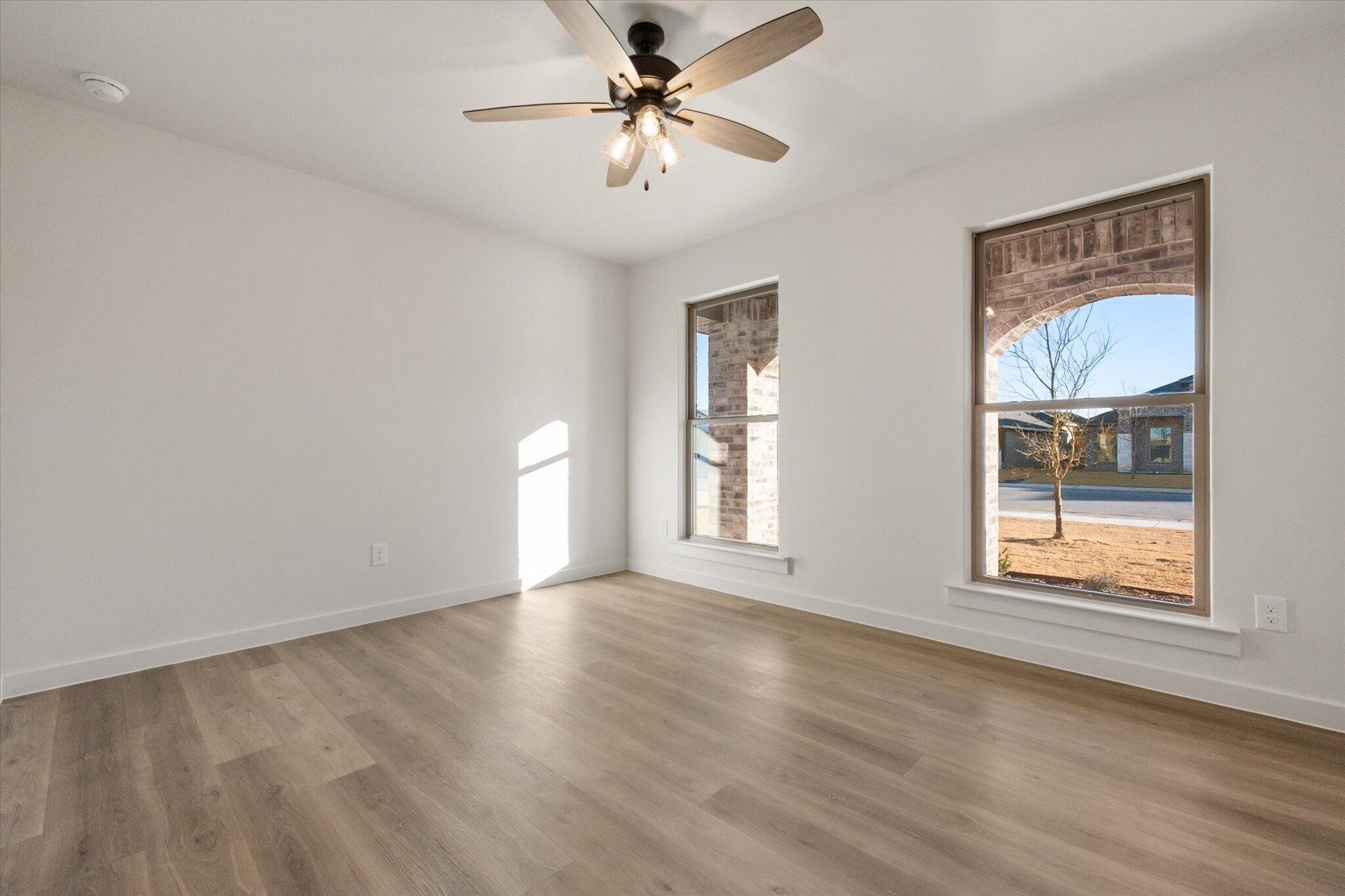 7006 56th Street Lubbock, TX 79407 - Photo 17 of 22 a view of an empty room with a window and wooden floor