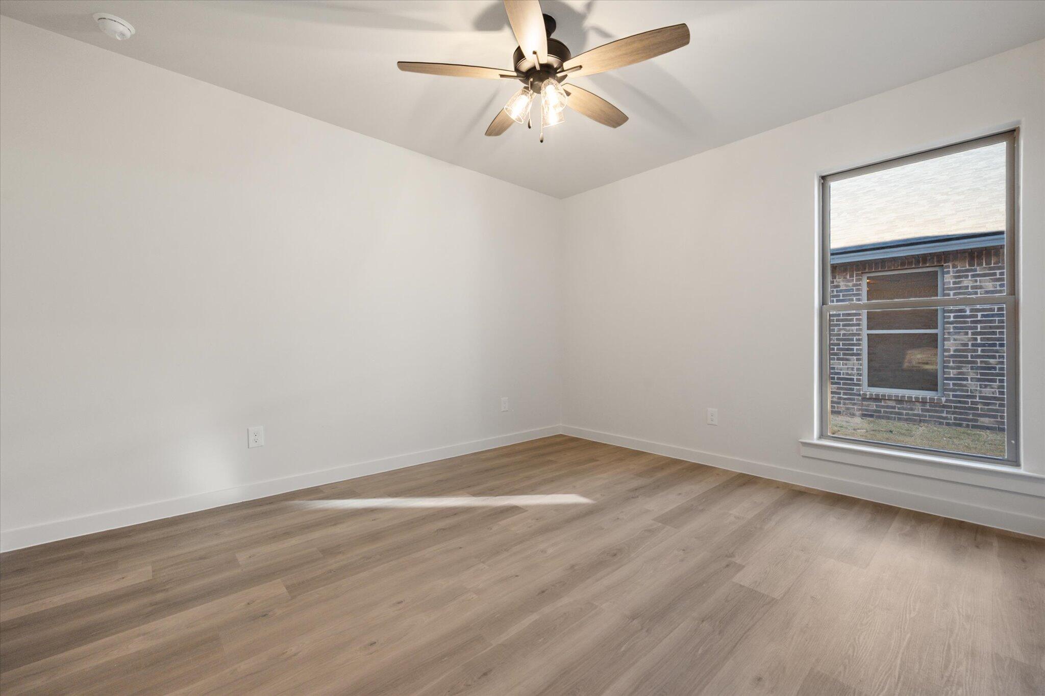 7006 56th Street Lubbock, TX 79407 - Photo 18 of 22 wooden floor in an empty room with a window