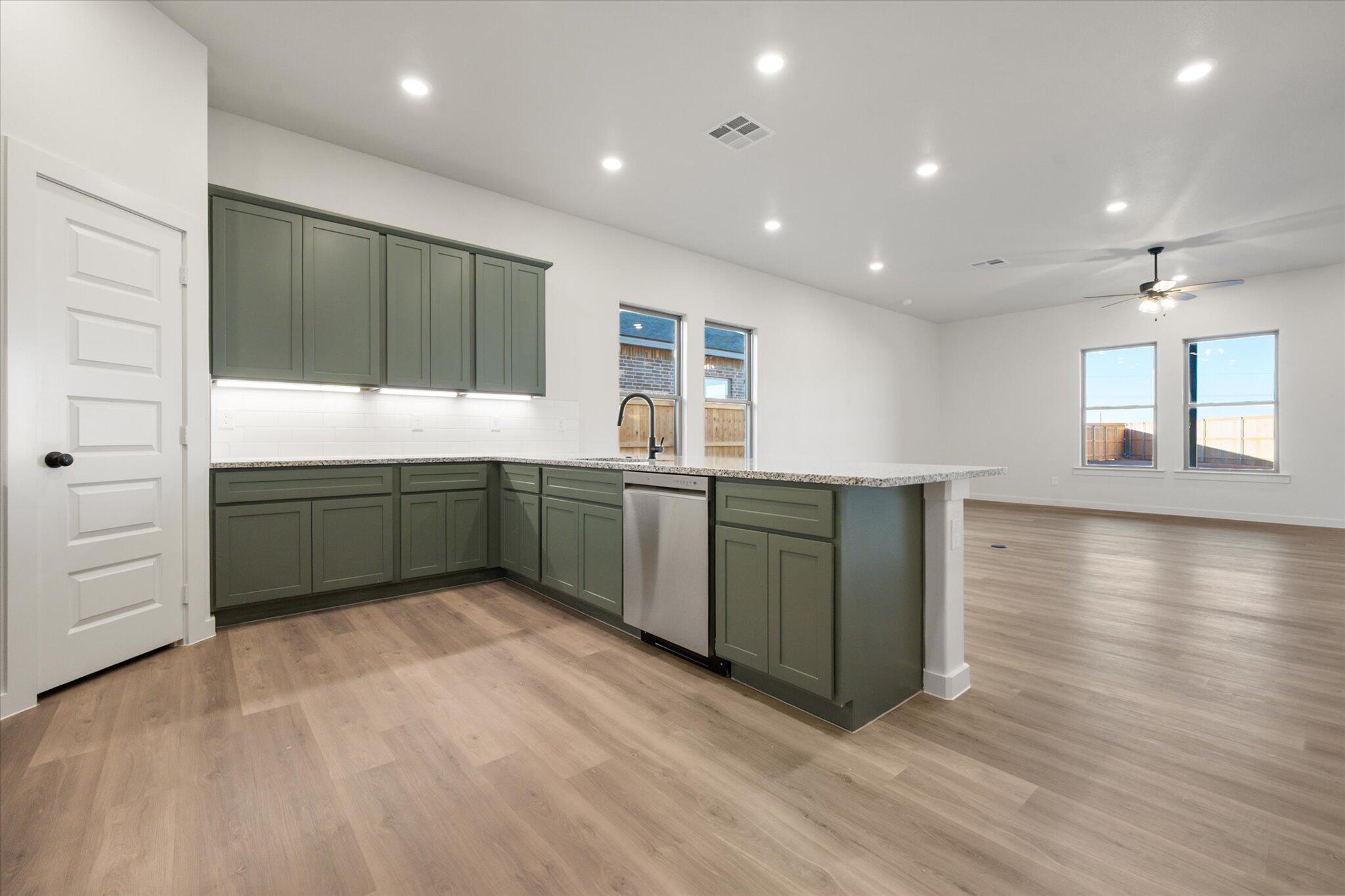 7006 56th Street Lubbock, TX 79407 - Photo 3 of 22 a room with lots of wooden cabinets a sink and dishwasher