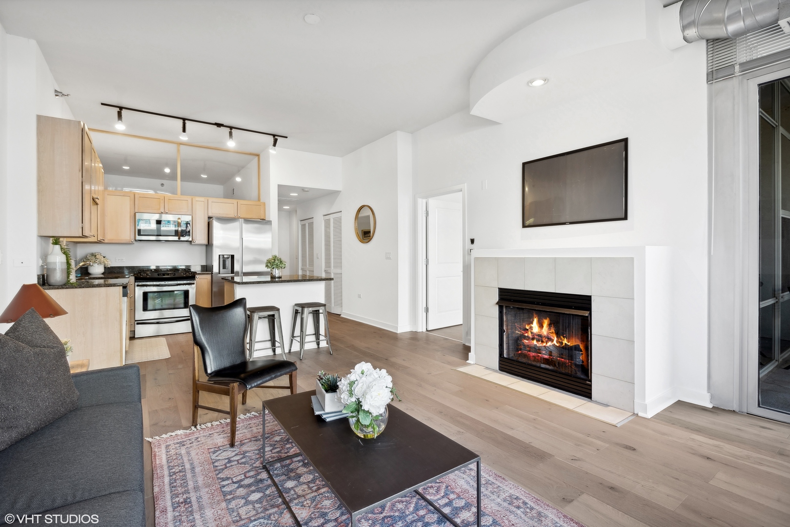 901 West Madison Street, Unit 615 Chicago, IL 60607 - Photo 6 of 25 a living room with furniture and a fireplace with kitchen view