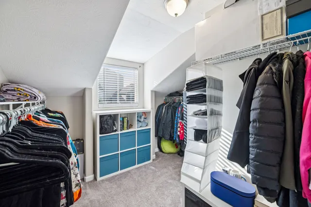 a view of walk in closet with clothes and shoes