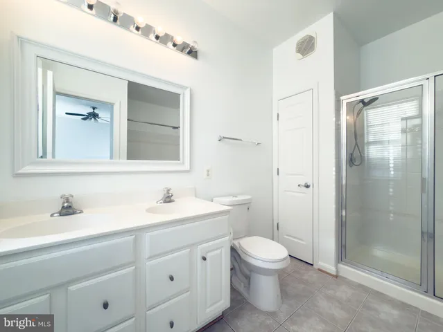 a bathroom with a toilet a sink a mirror and shower
