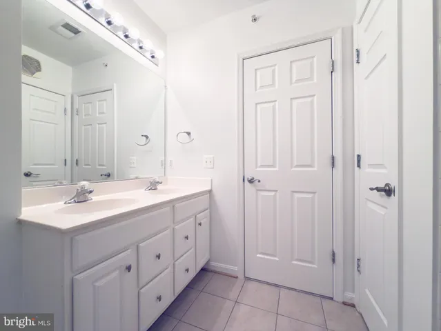 a bathroom with a double vanity sink and a mirror