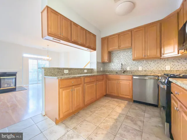 a kitchen with stainless steel appliances granite countertop a stove sink and cabinets
