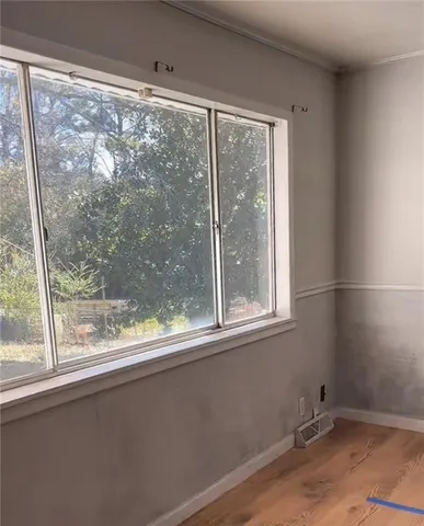 a view of a small space with wooden floor and a window