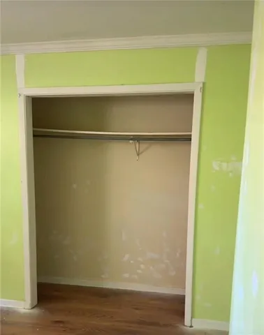 a view of a small space with wooden floor and a window