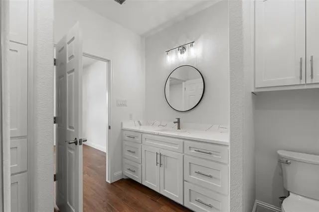 a bathroom with a toilet a sink and a mirror