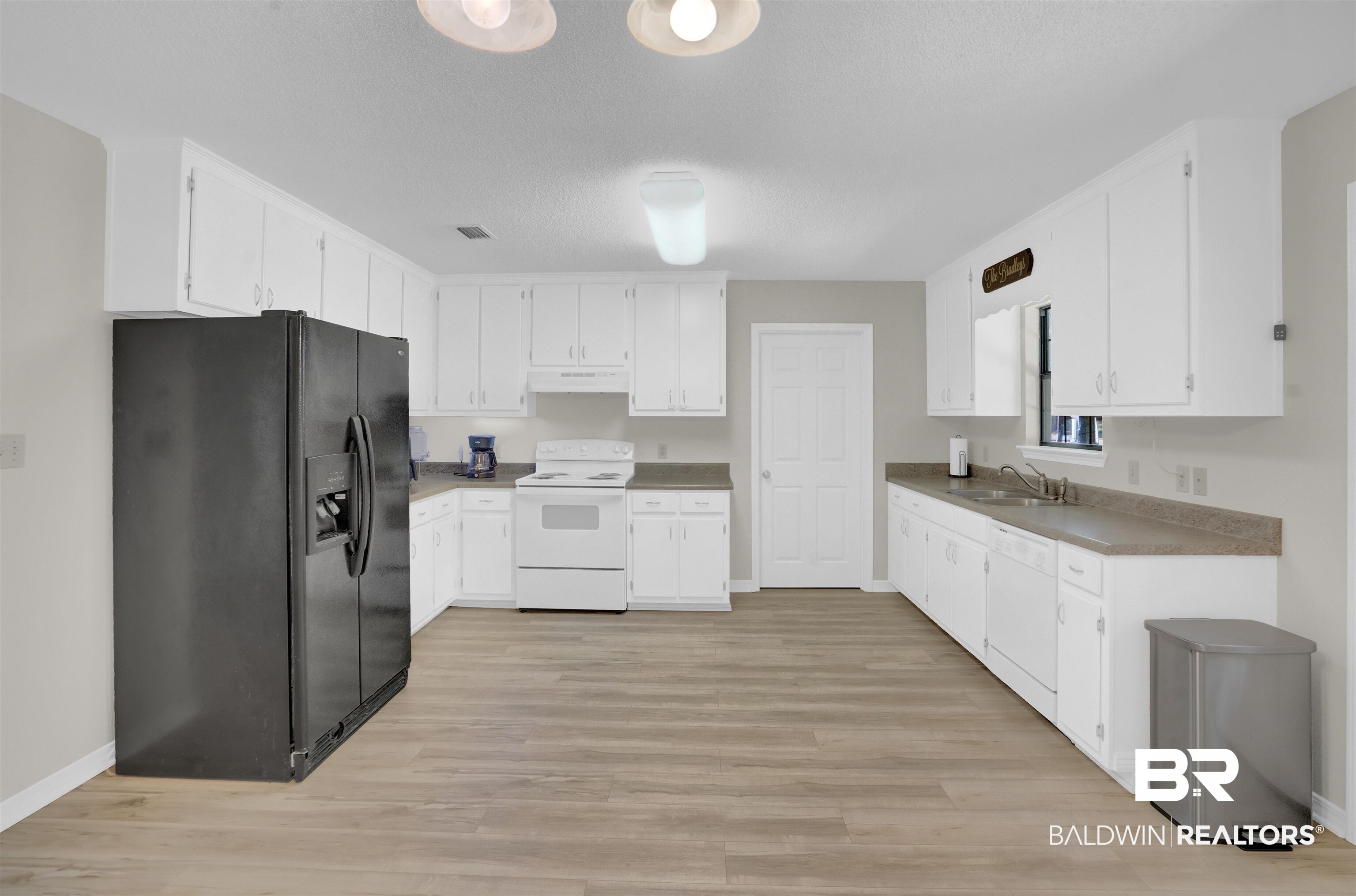 30871 Stanton Road Spanish Fort, AL 36527 - Photo 11 of 35 Kitchen featuring sink, white appliances, white cabinetry, and light hardwood / wood-style flooring