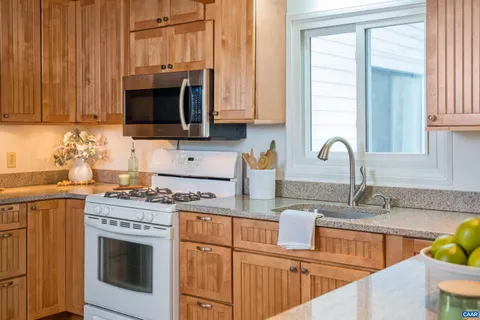 a living room with stainless steel appliances granite countertop furniture and a large window