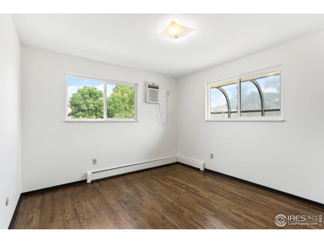 5758 Rustic Knolls Drive Boulder, CO 80301 - Photo 18 of 28 an empty room with wooden floor and windows