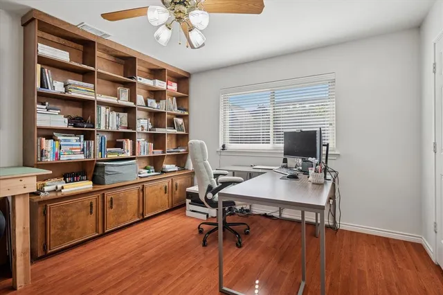 a view of a workspace with furniture and a window